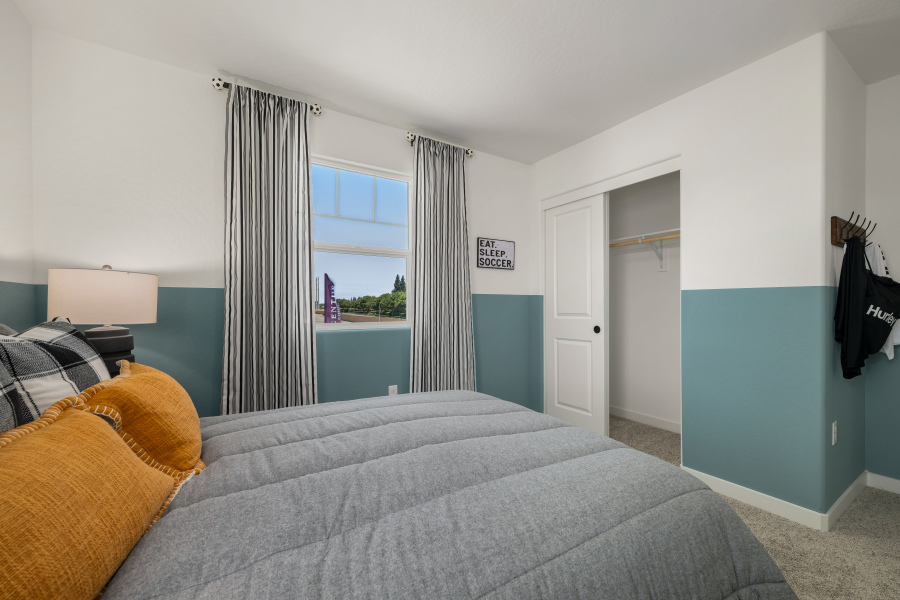 A bedroom with a couch and a window.