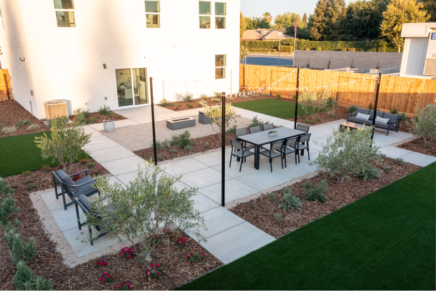 A backyard with a table and chairs.