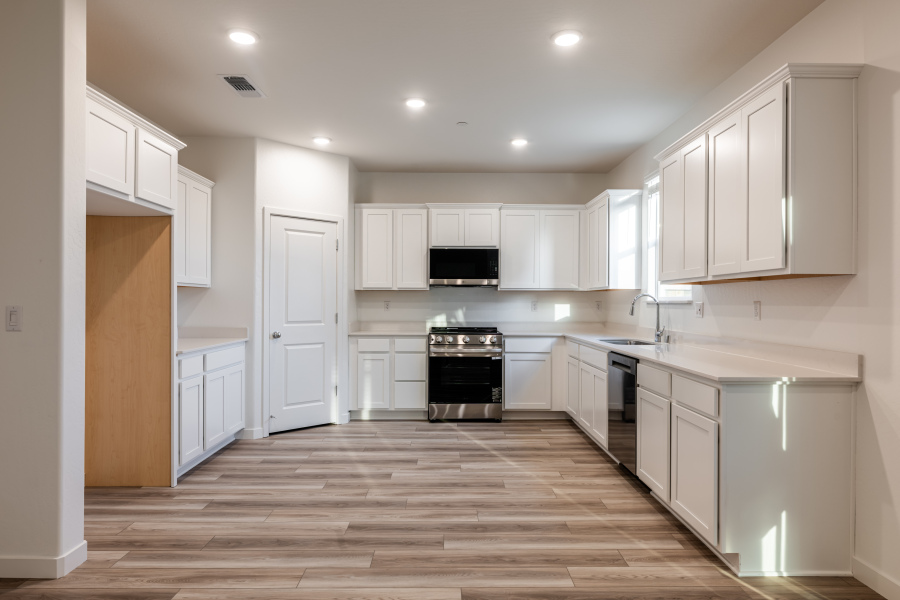 A kitchen with white cabinets.