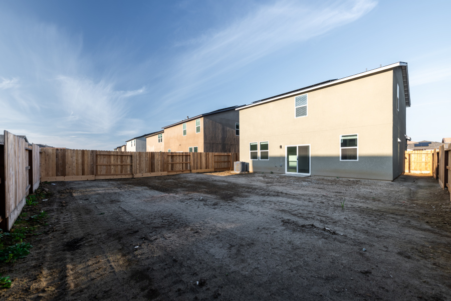 A dirt road leading to a building.