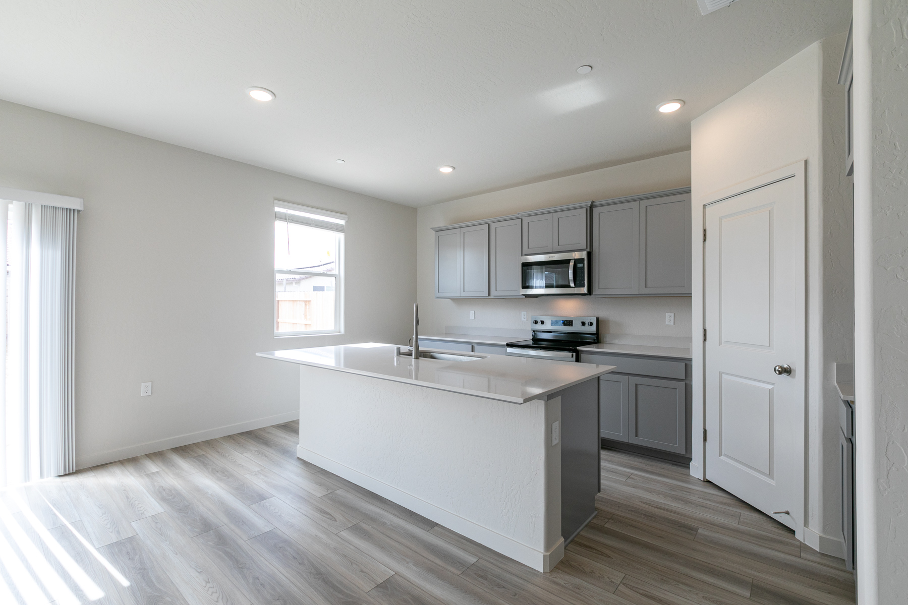 A kitchen with white cabinets.