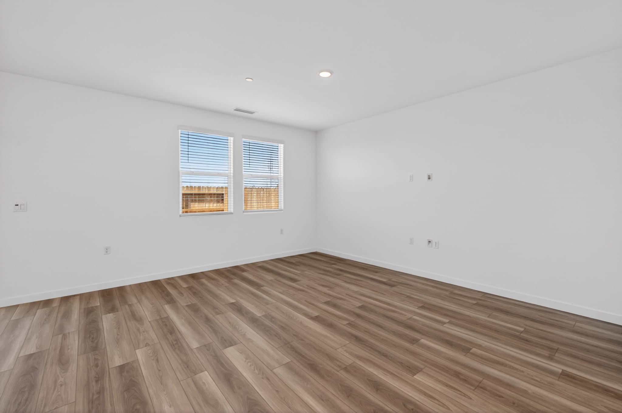 A room with a wood floor and a window.