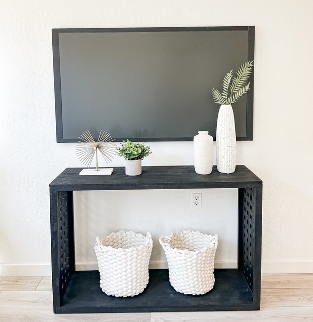 A black and white shelf with white vases and white vases.