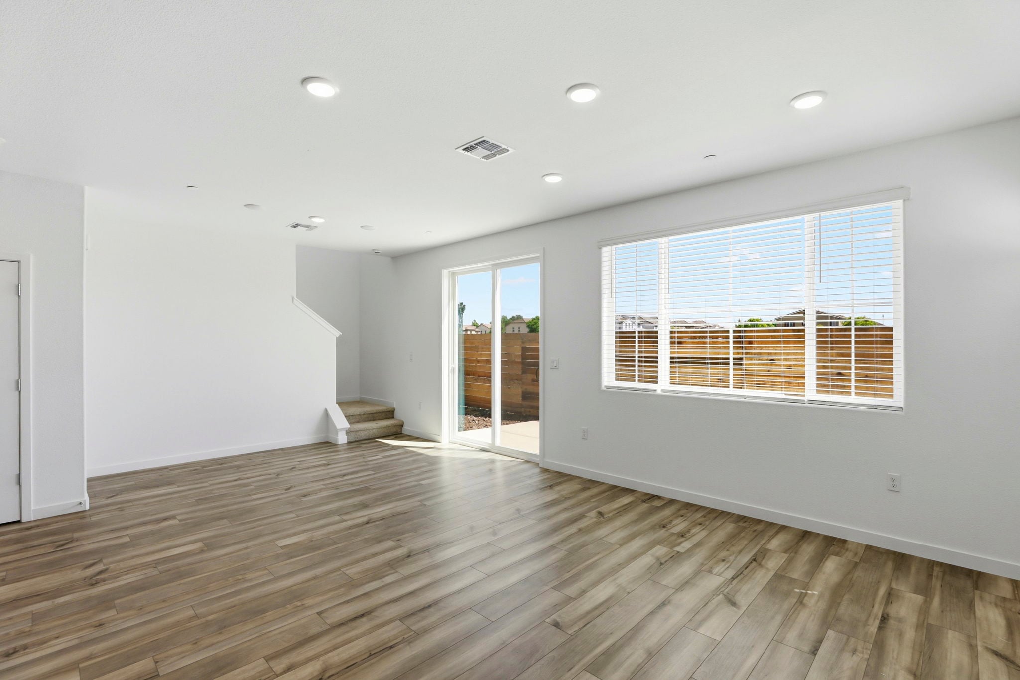 A room with a wood floor and a wood floor with a window.