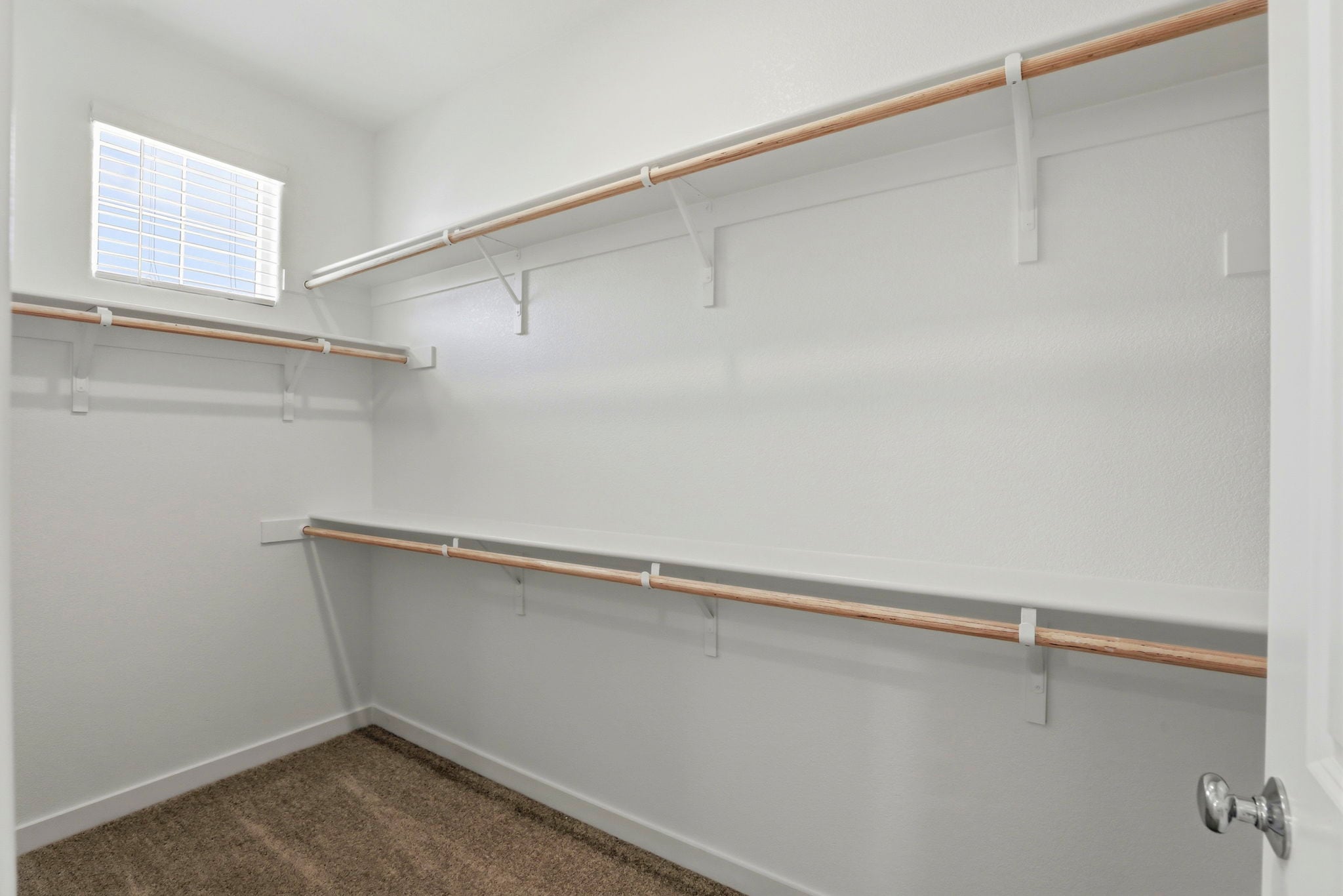 A white wall with a metal bar.
