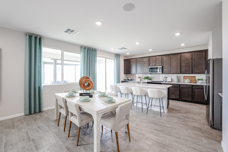 A kitchen with a dining table and chairs.