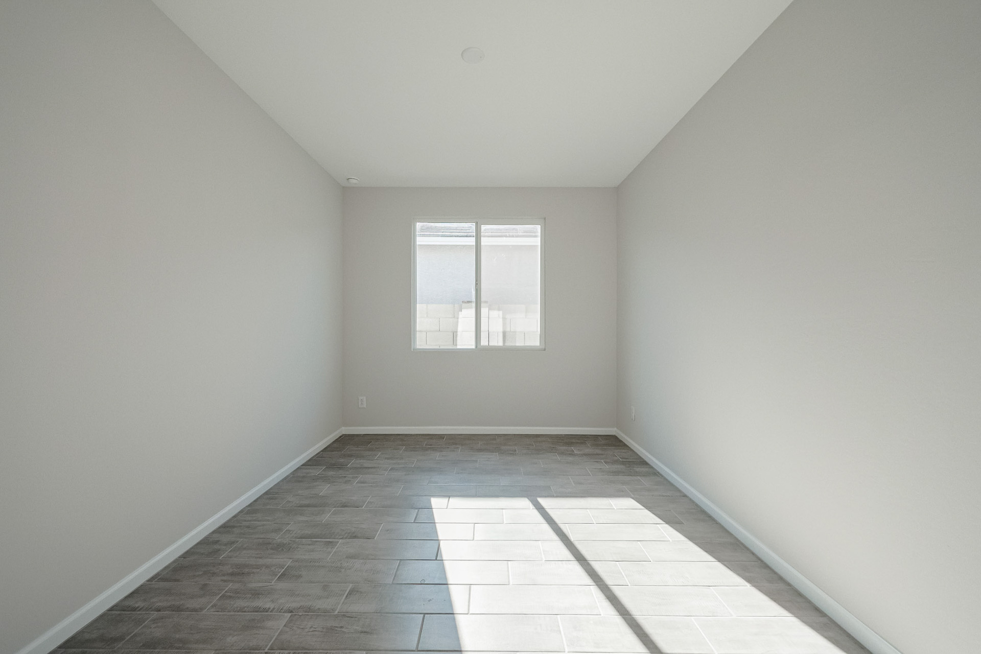A room with a window and a tile floor.