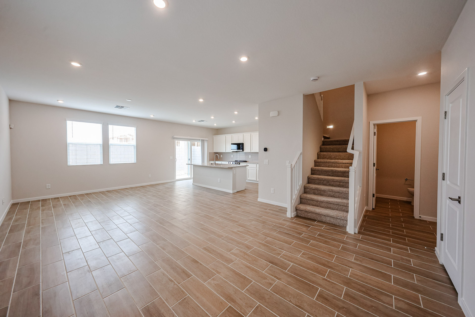 A large empty room with a wood floor and white walls.