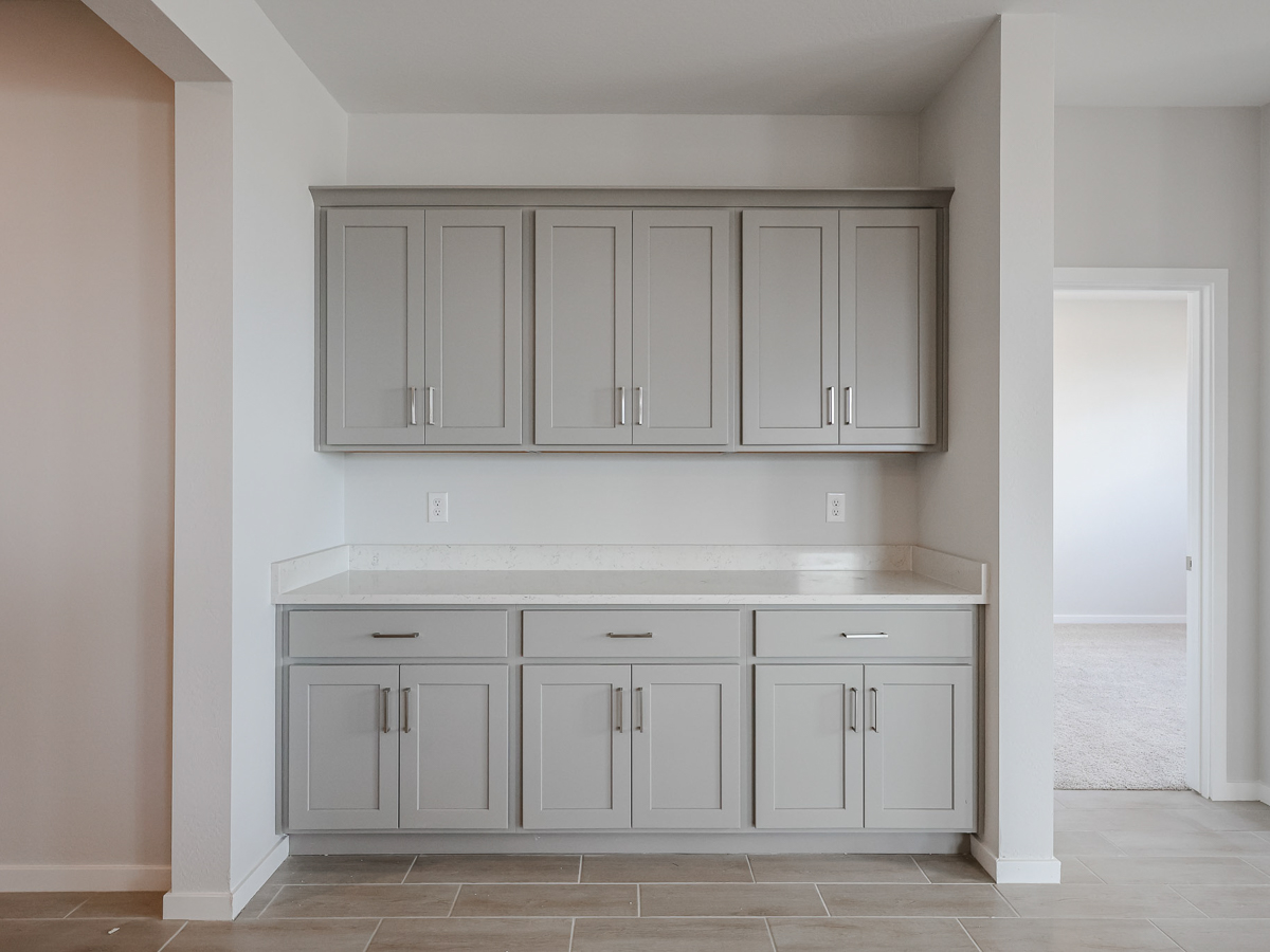 A kitchen with white cabinets.