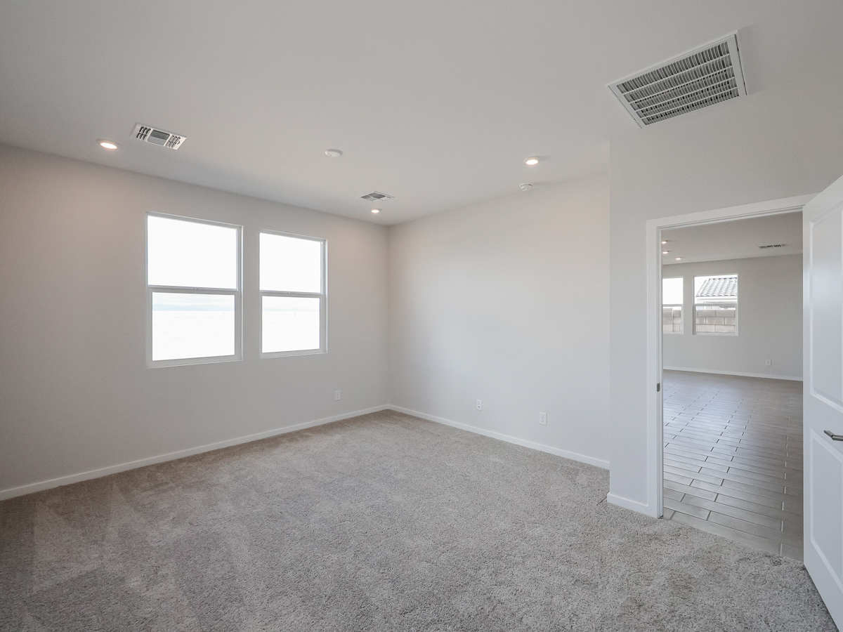 A room with a carpet and windows.