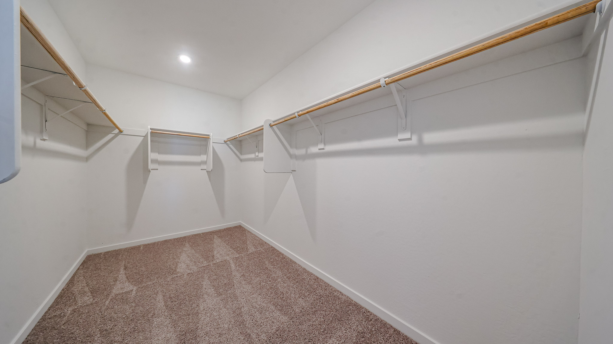 A white hallway with a carpet.