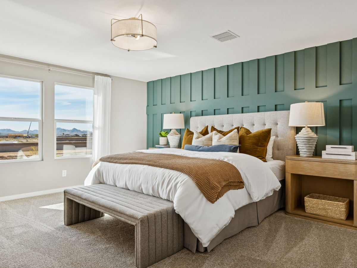 A bedroom with a bed and a bench.