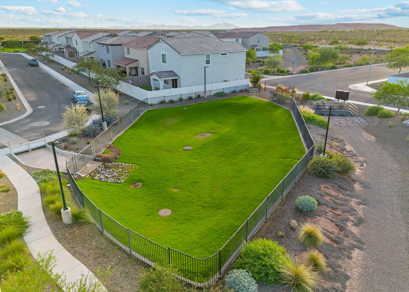 A fenced in yard with houses in the background.