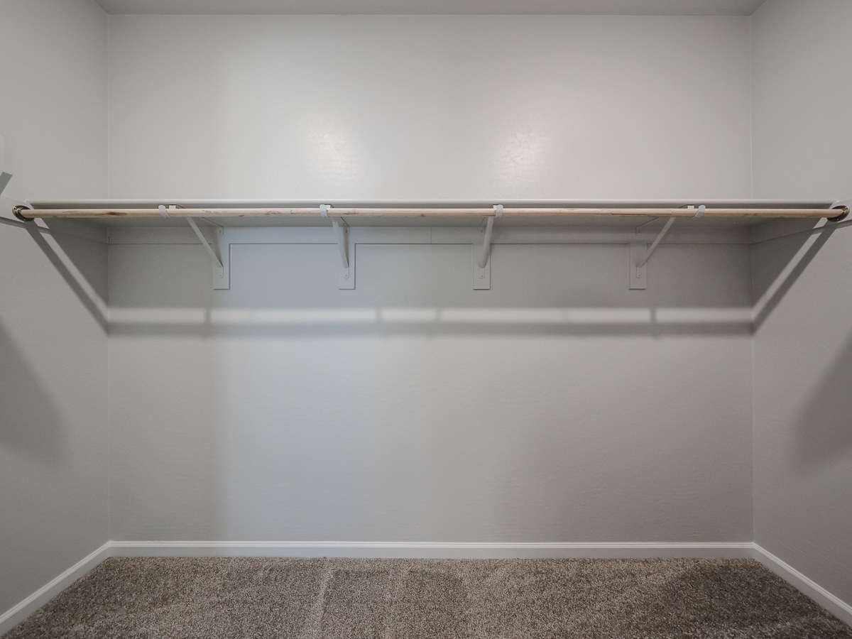 A white wall with a metal bar.