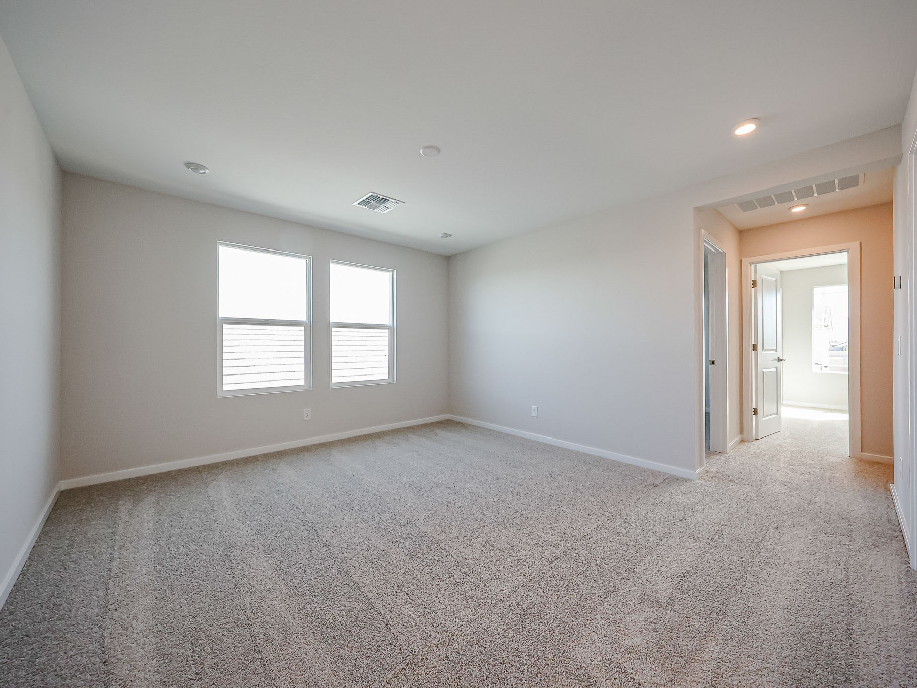 A room with a carpet and windows.