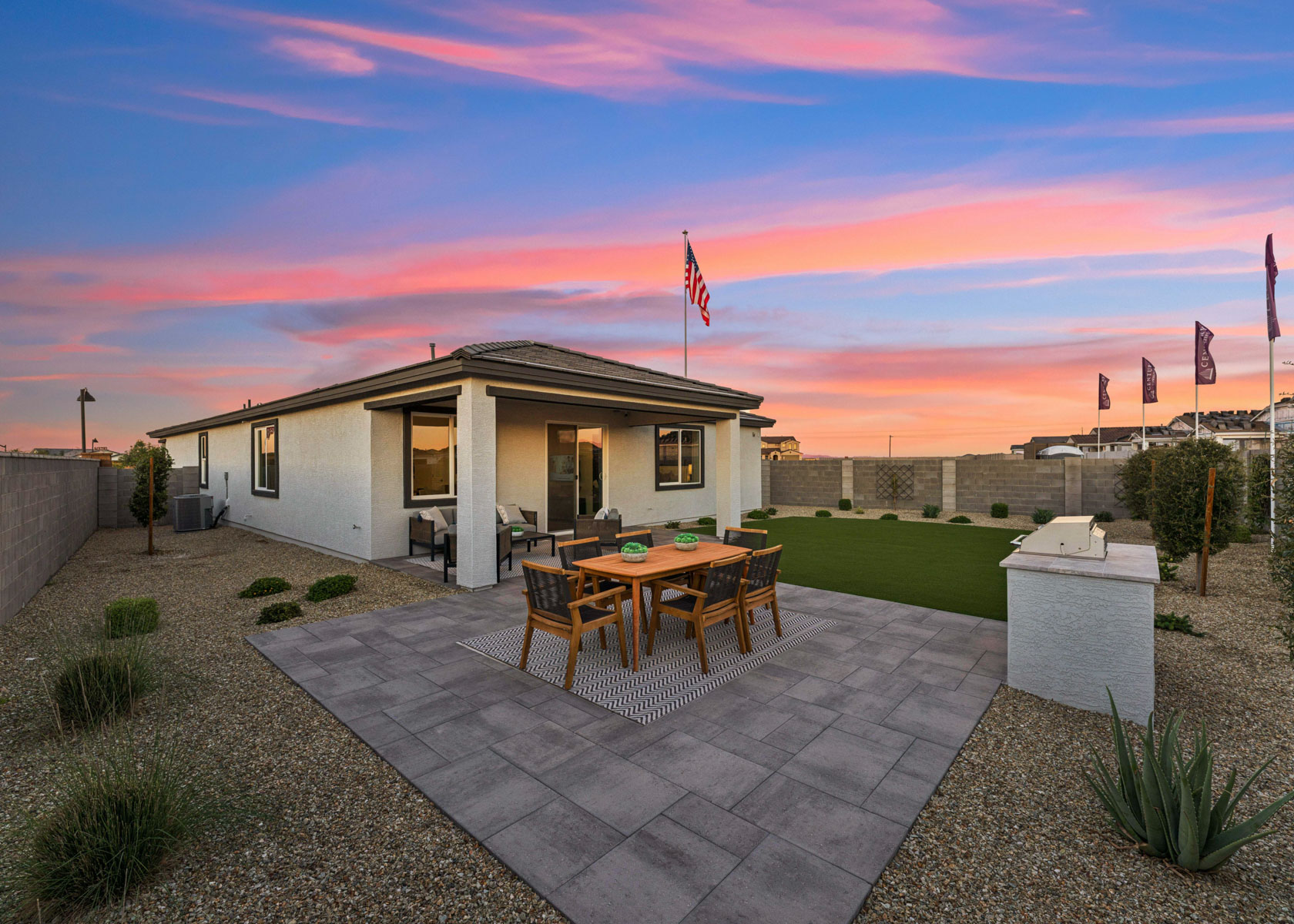 A house with a patio and a table and chairs in the front.