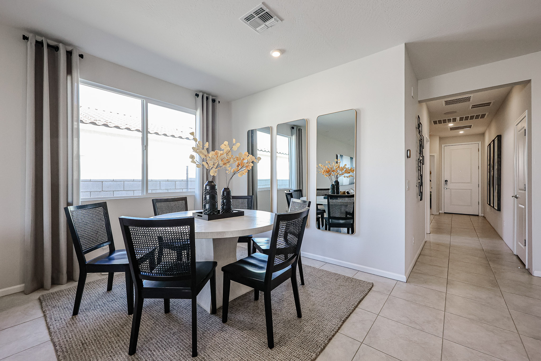 A dining room with a table and chairs.