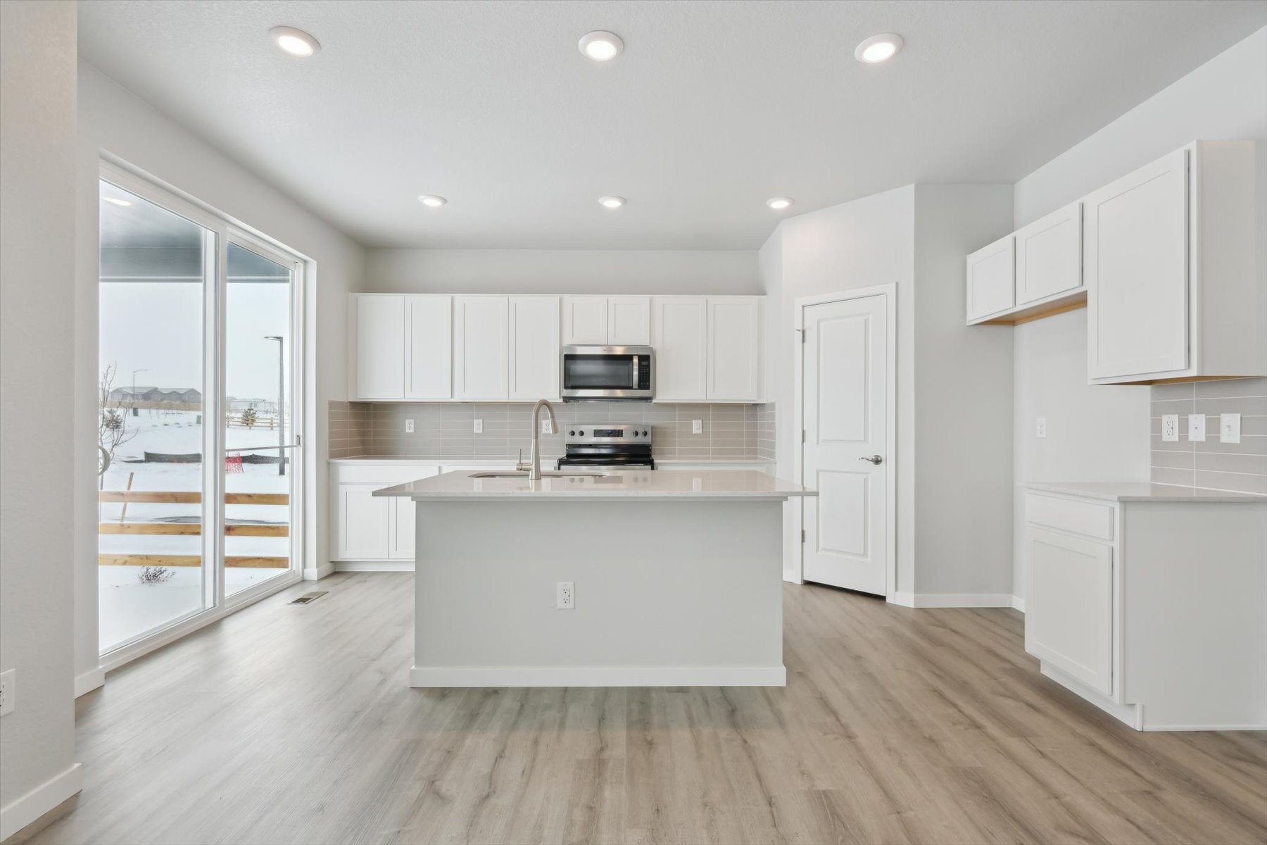 A kitchen with white cabinets.