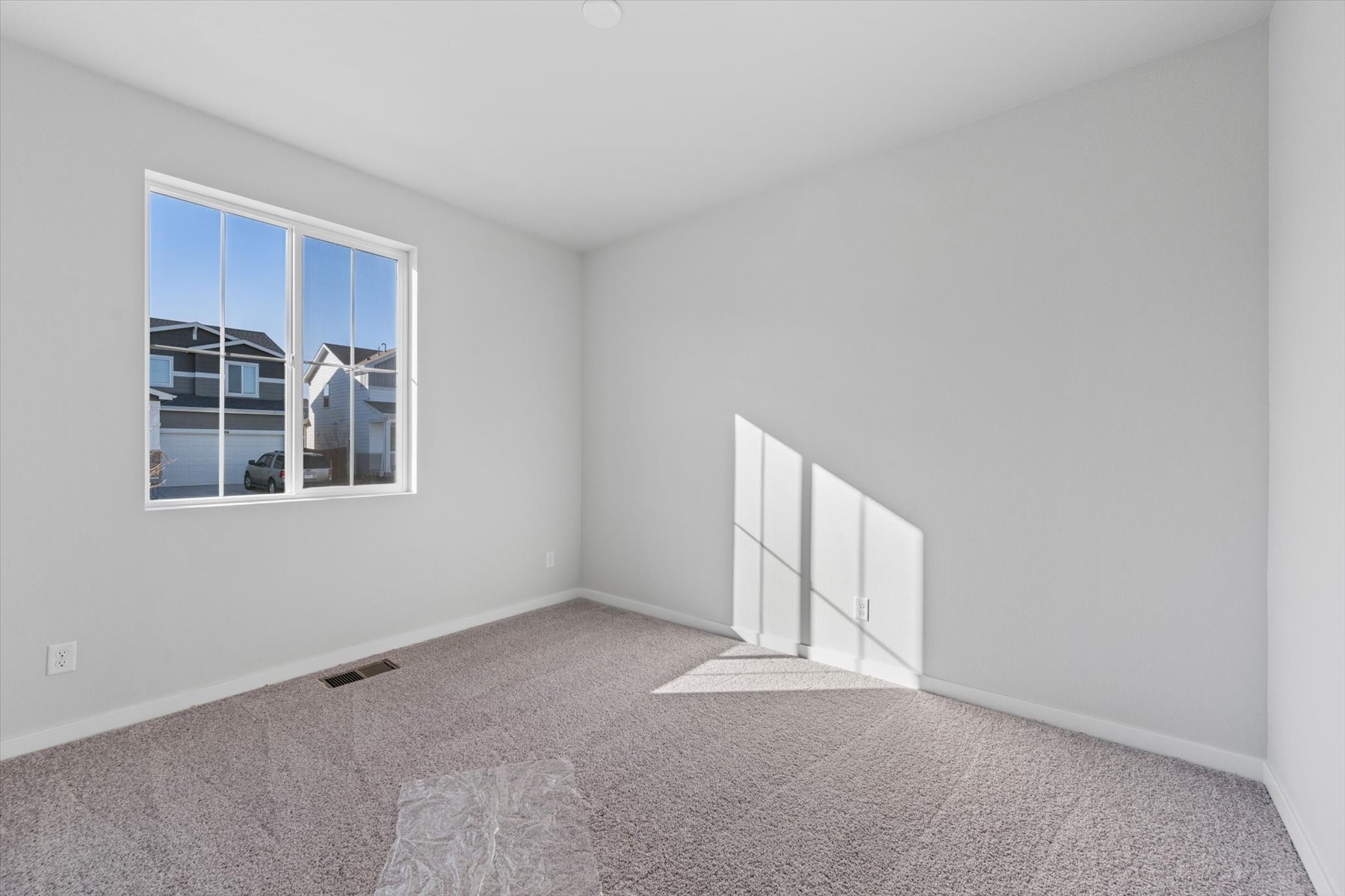 A room with a window and carpet.