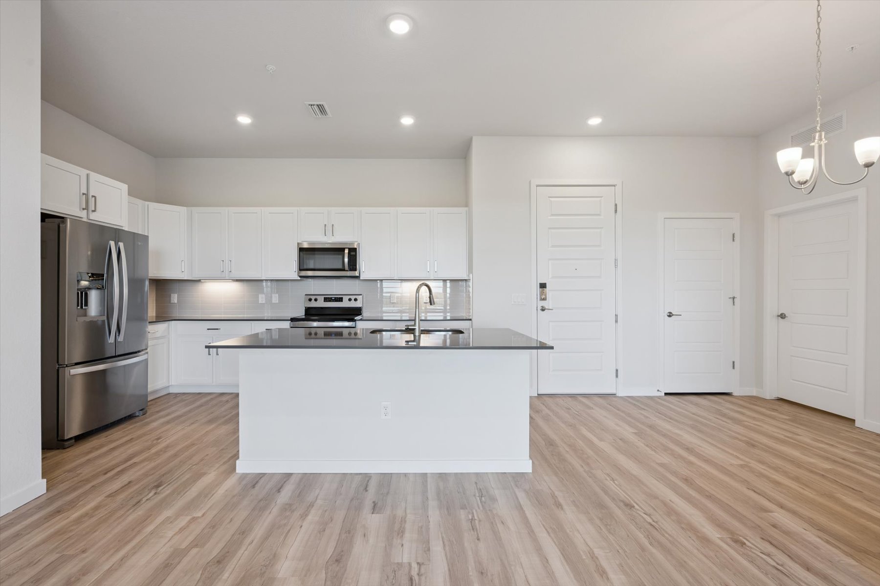 A kitchen with white cabinets.