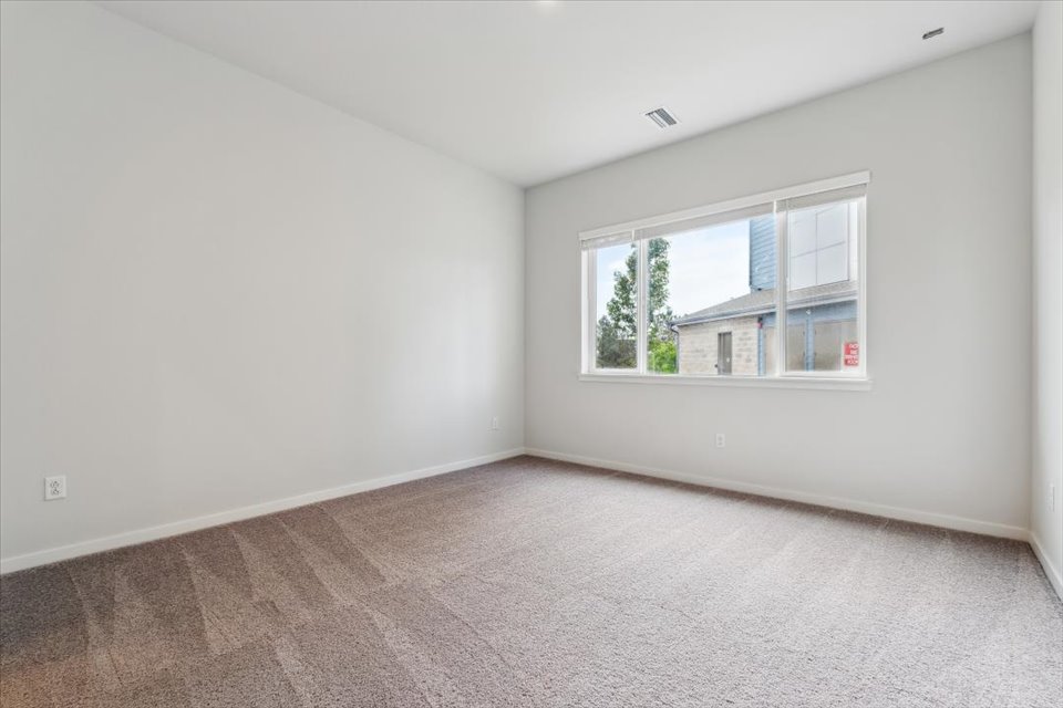 A room with a window and a carpet.