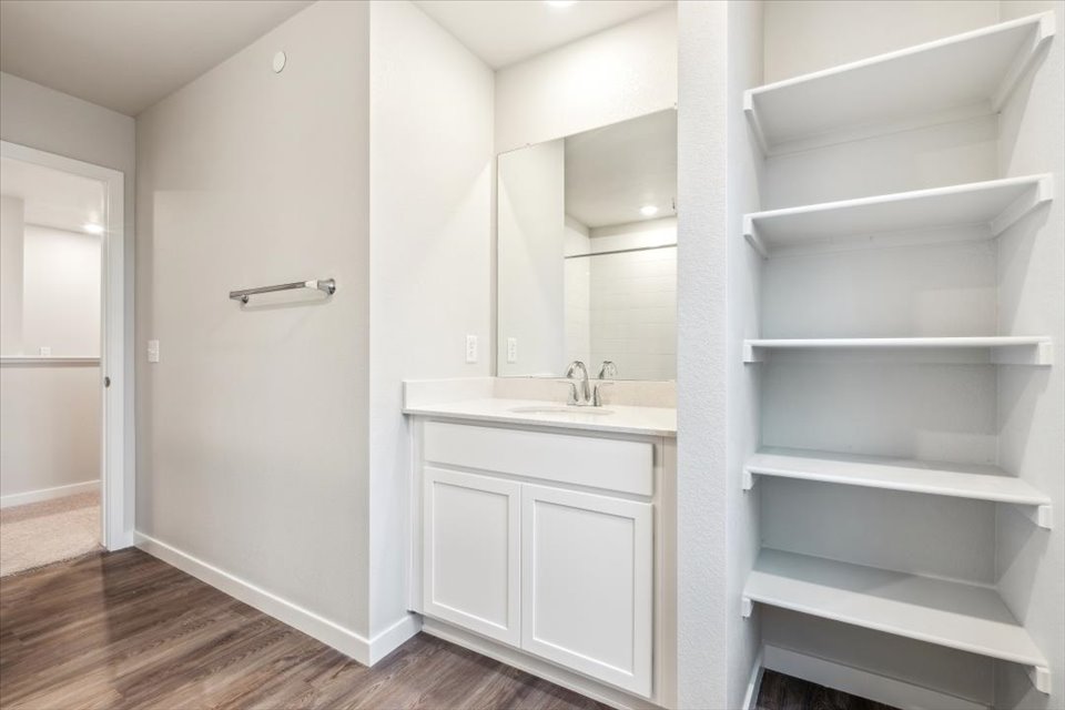 A bathroom with white cabinets.