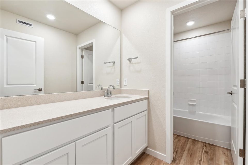 A bathroom with a sink and a shower.