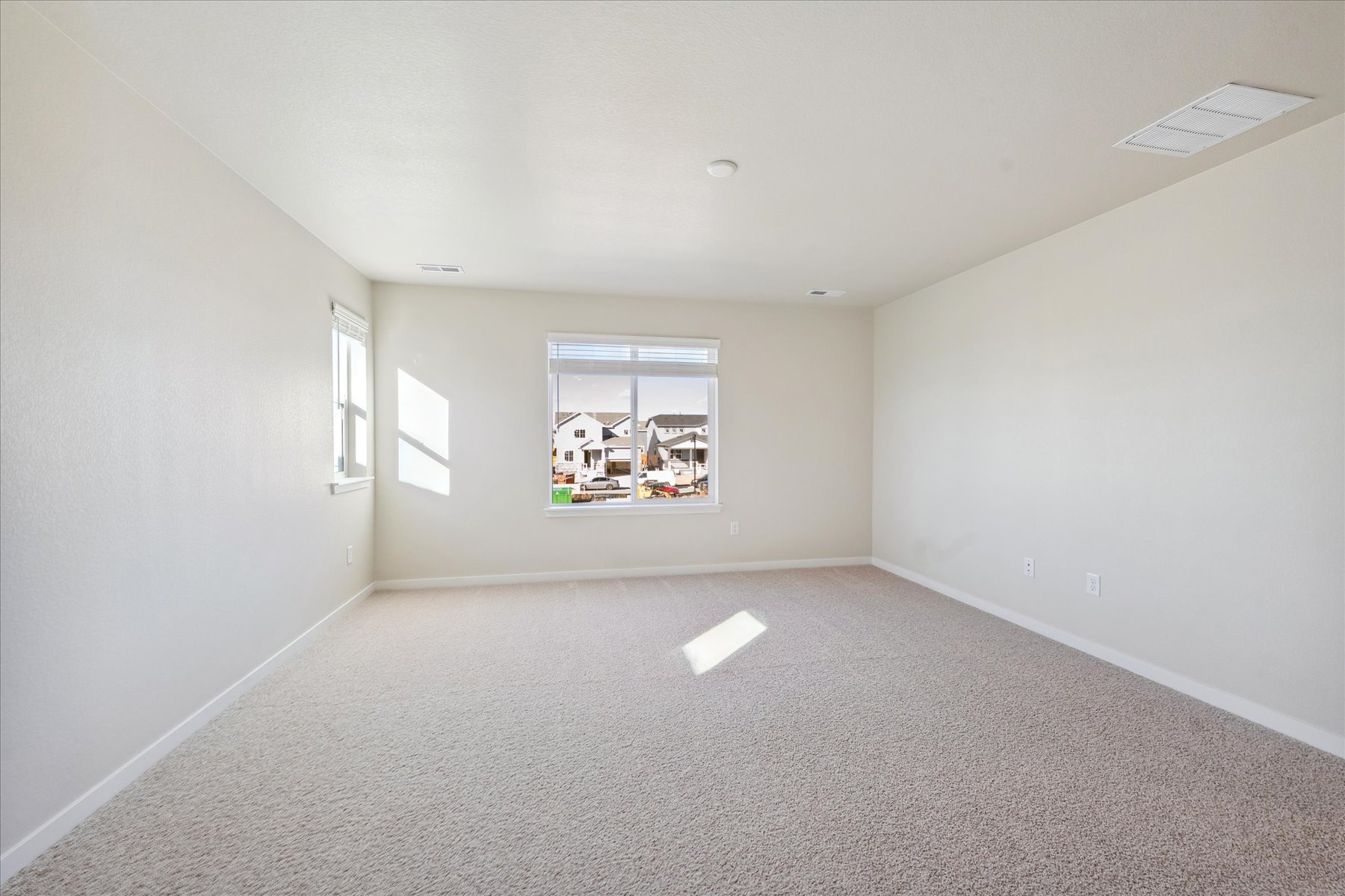 A room with a window and a white wall.