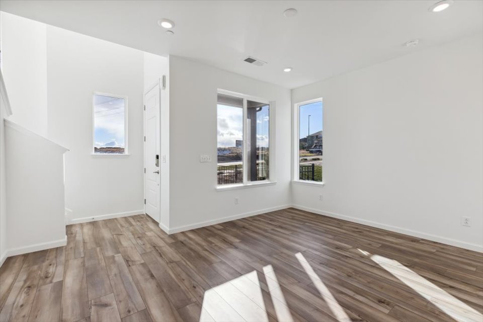 A room with a wood floor and a wood floor with a window.
