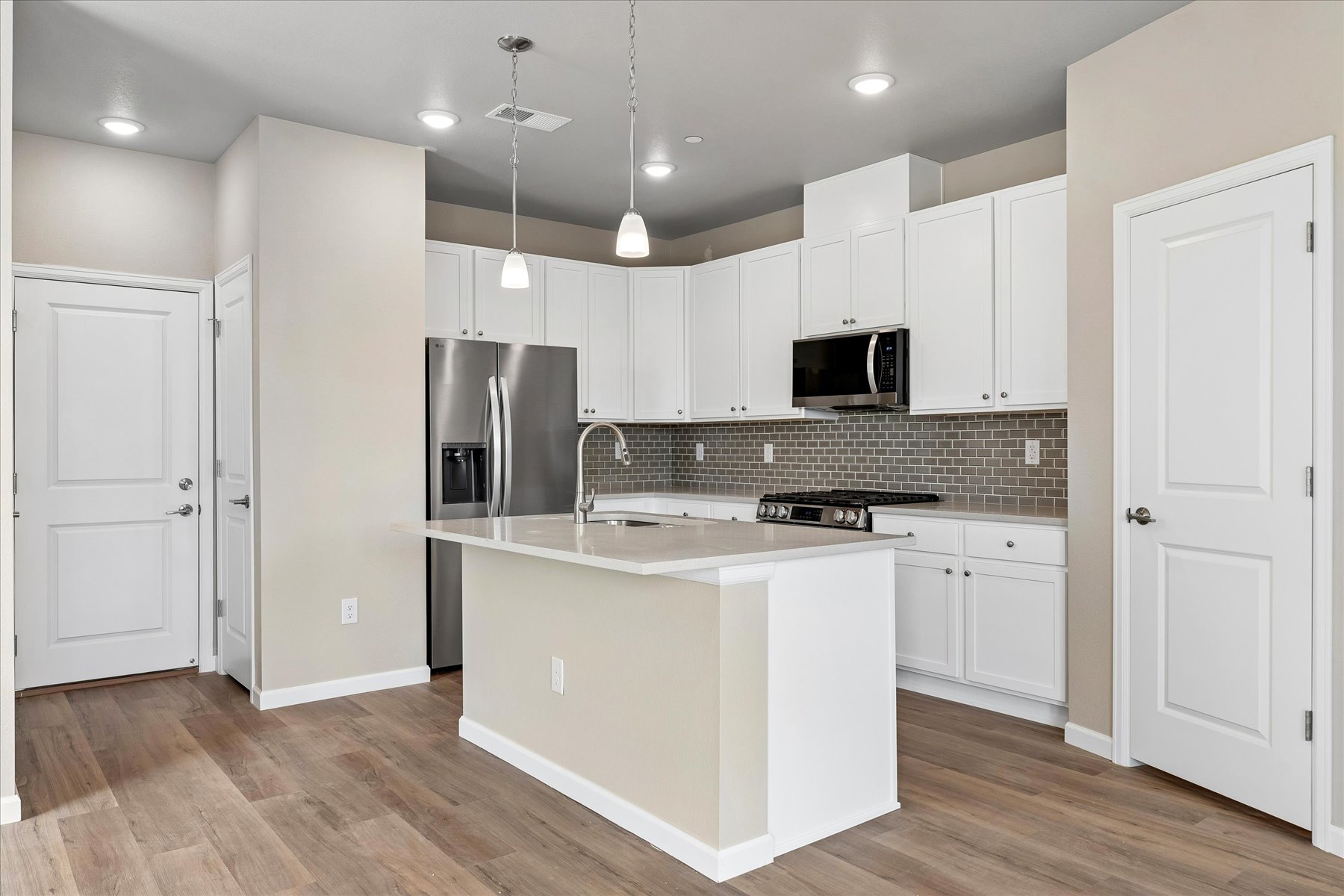 A kitchen with white cabinets.