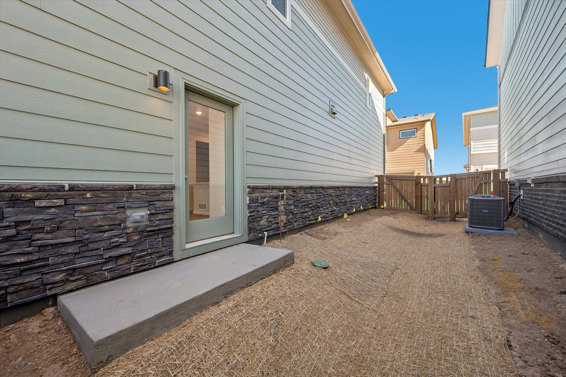 A house with a fence and a dirt yard.