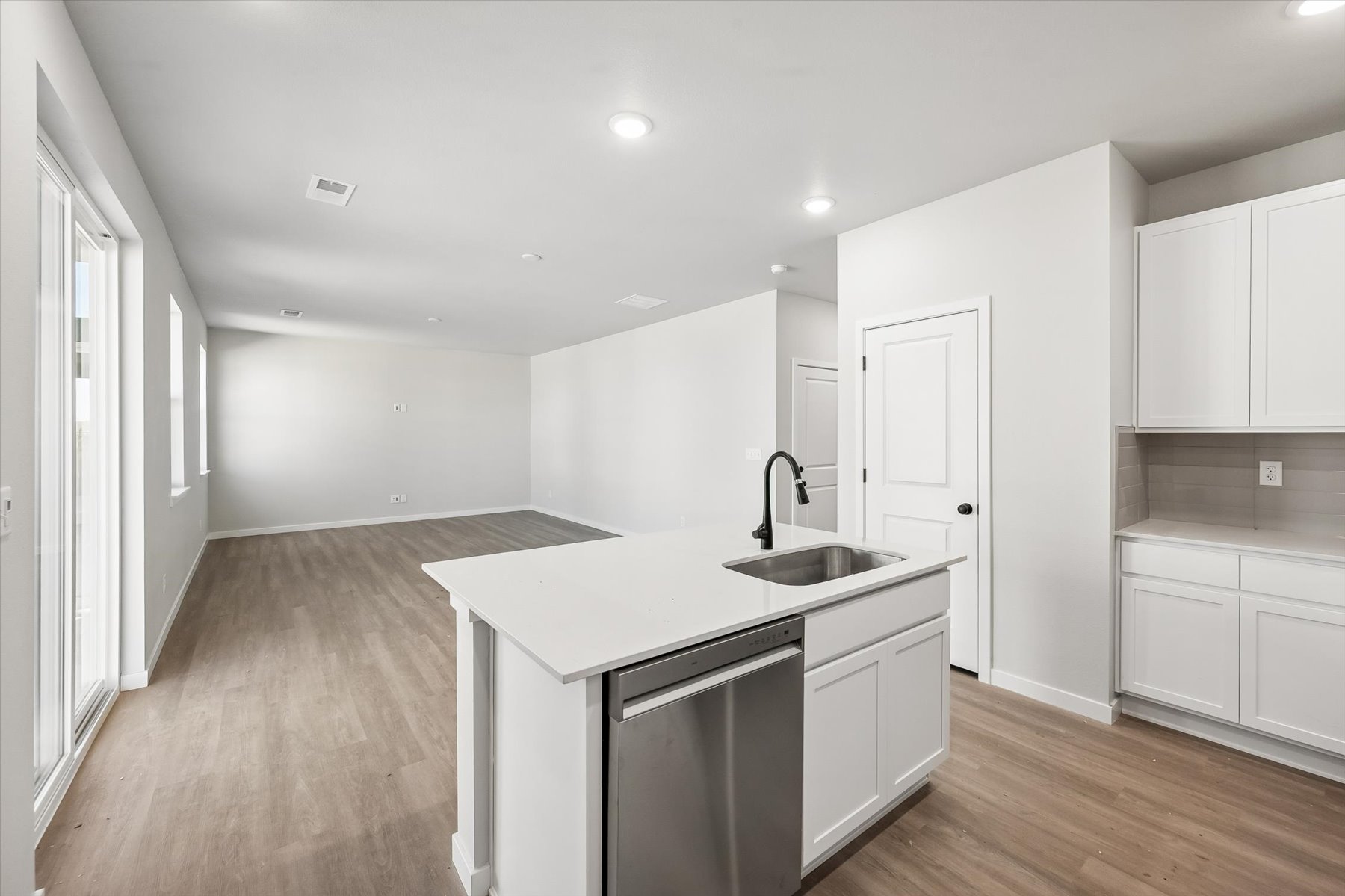 A kitchen with white cabinets.
