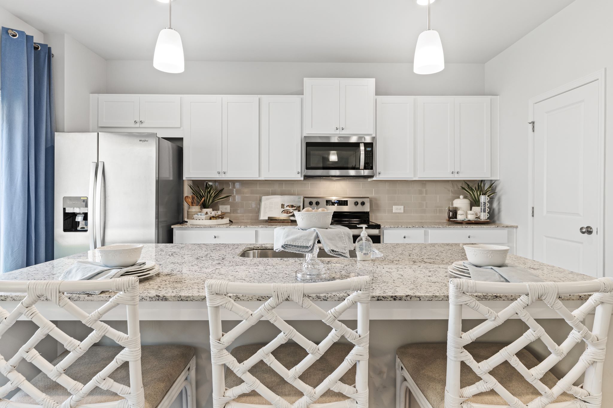 A kitchen with white cabinets.