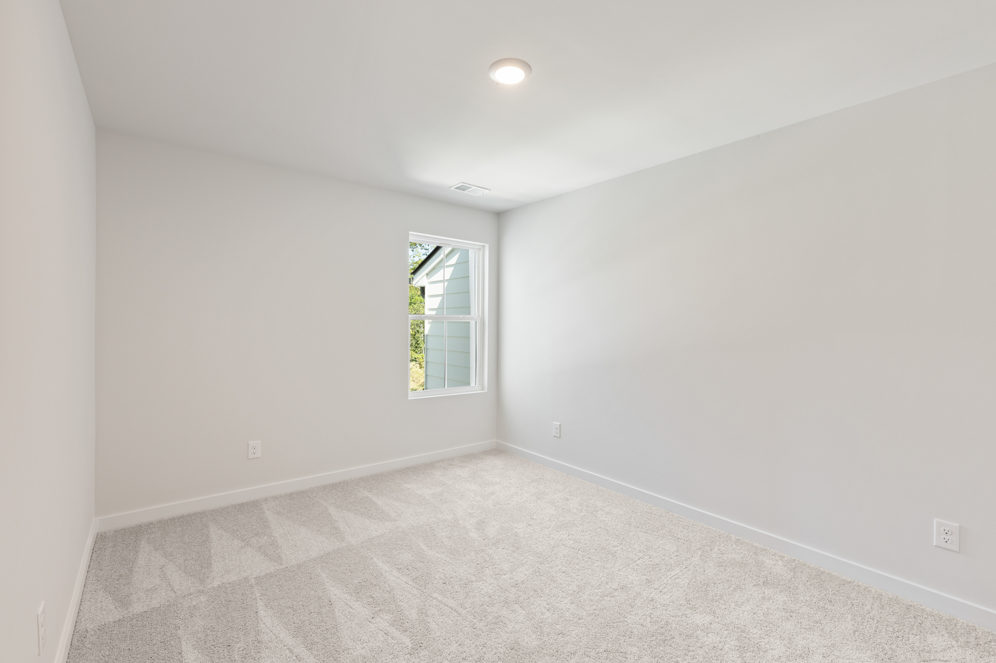 A room with a window and a carpet.