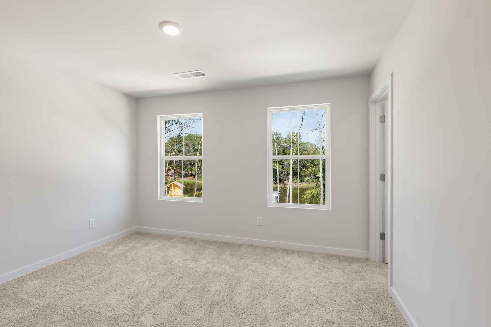 A room with windows and carpet.