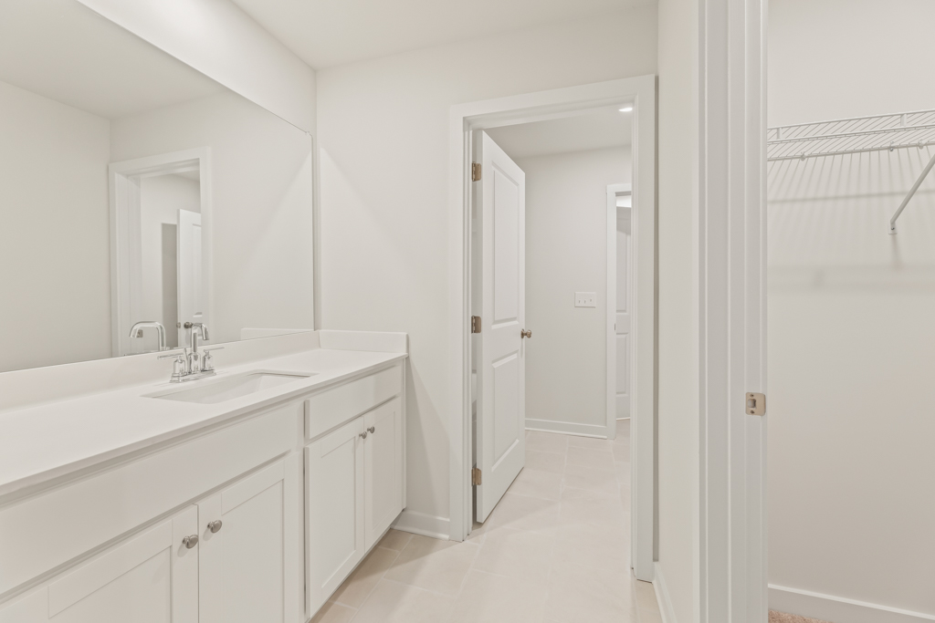 A bathroom with white cabinets.