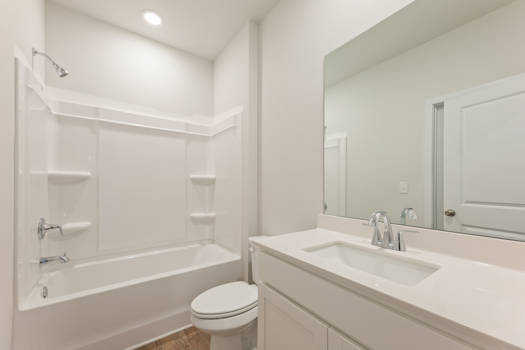 A bathroom with a tub sink and toilet.