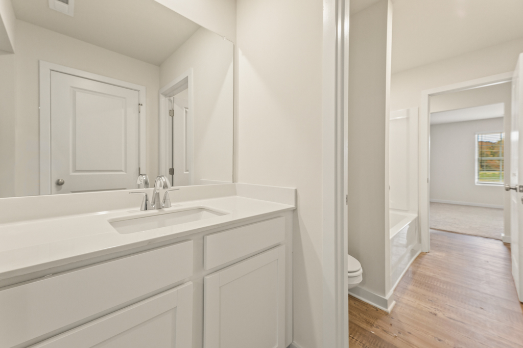 A bathroom with white cabinets.