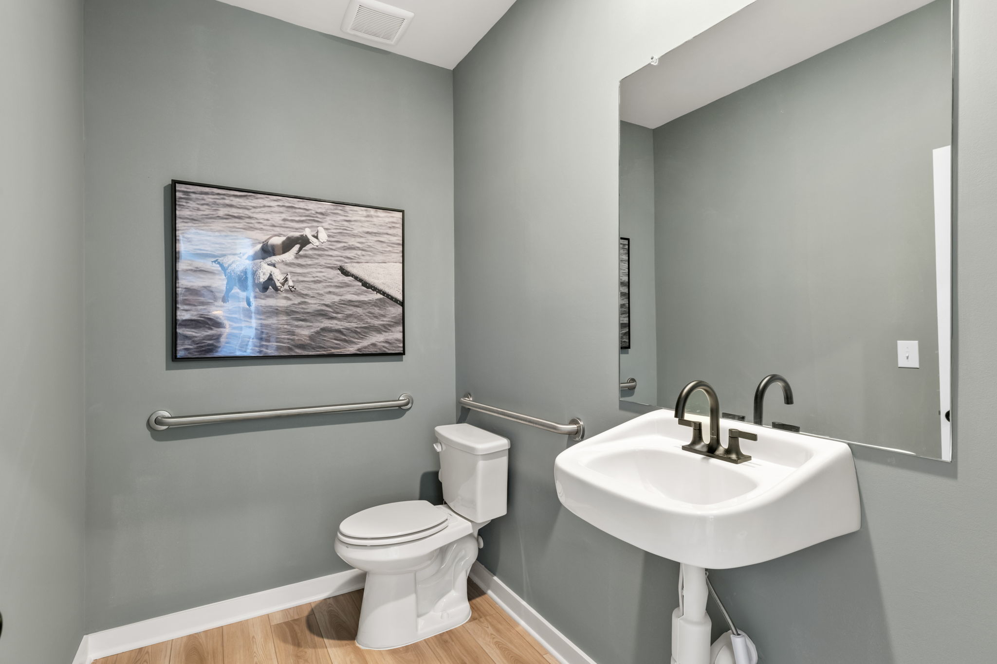 A bathroom with a picture on the wall.