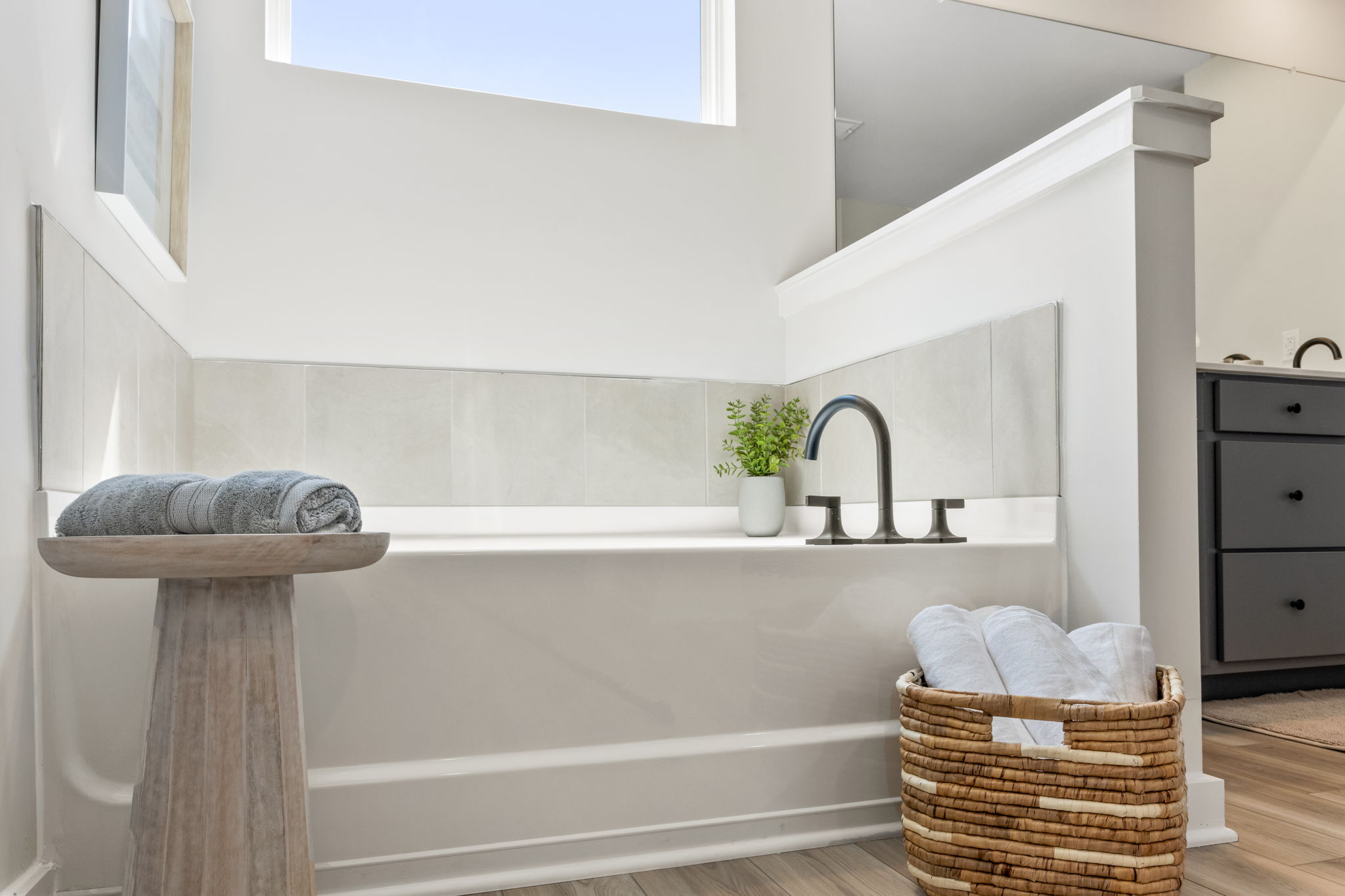 A bathtub with a basket and towels in it.