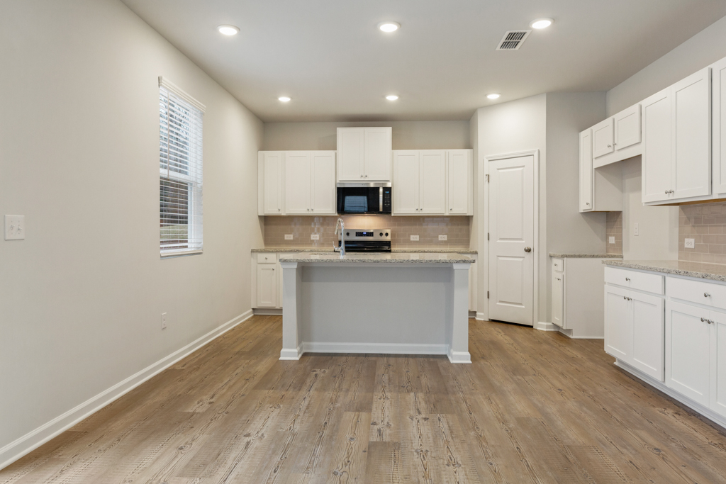 A kitchen with white cabinets.