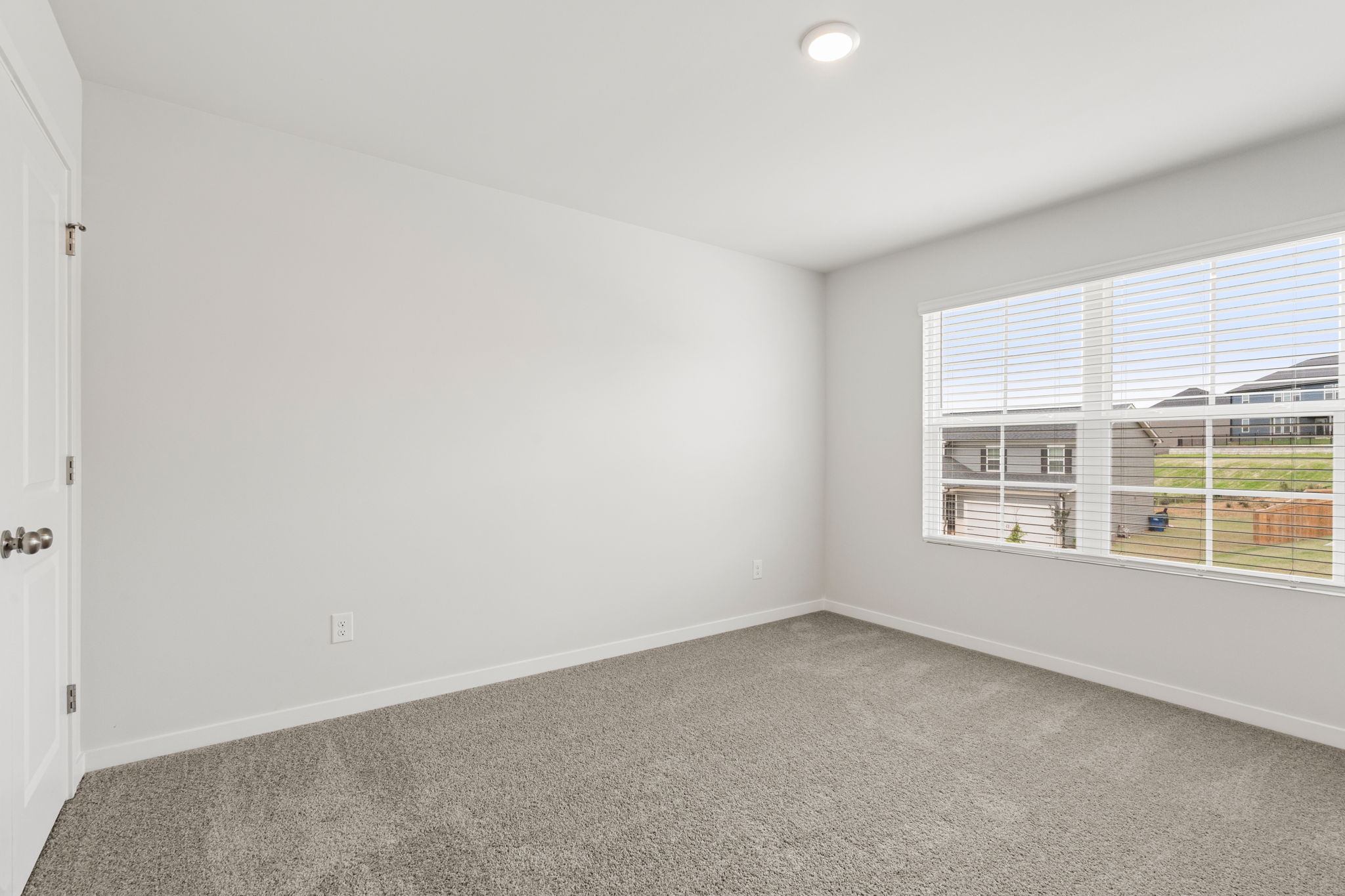 A room with a window and a carpet.