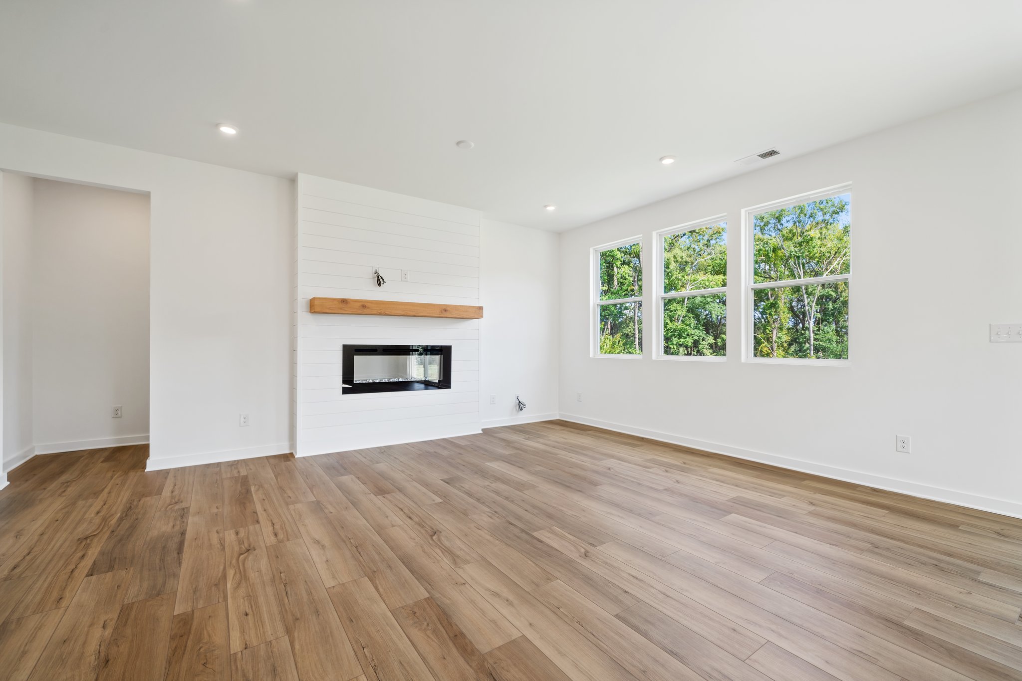A room with a fireplace and a wood floor.