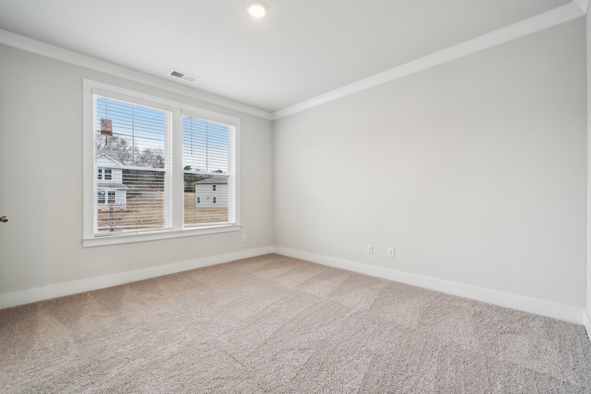 A room with a window and a carpet.