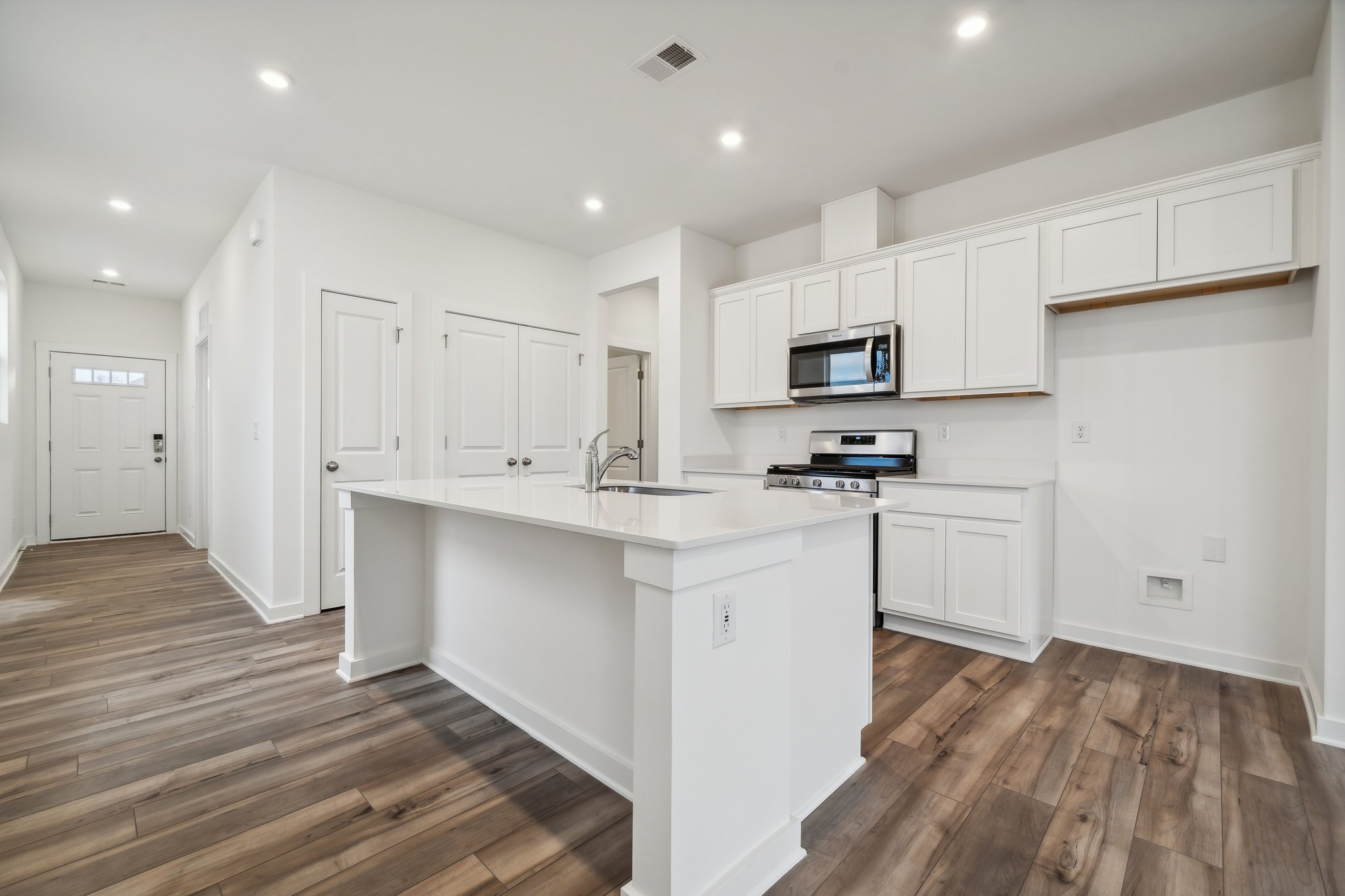 A kitchen with white cabinets.