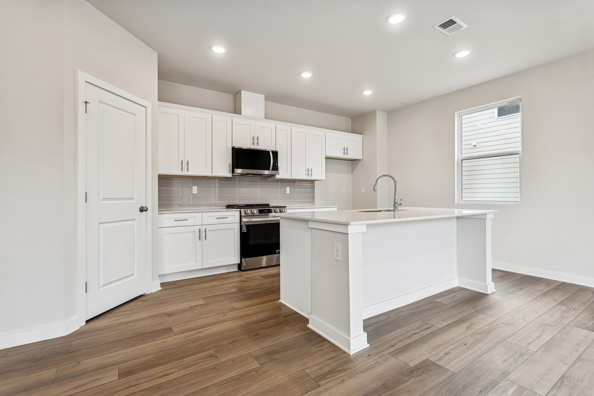 A kitchen with white cabinets.