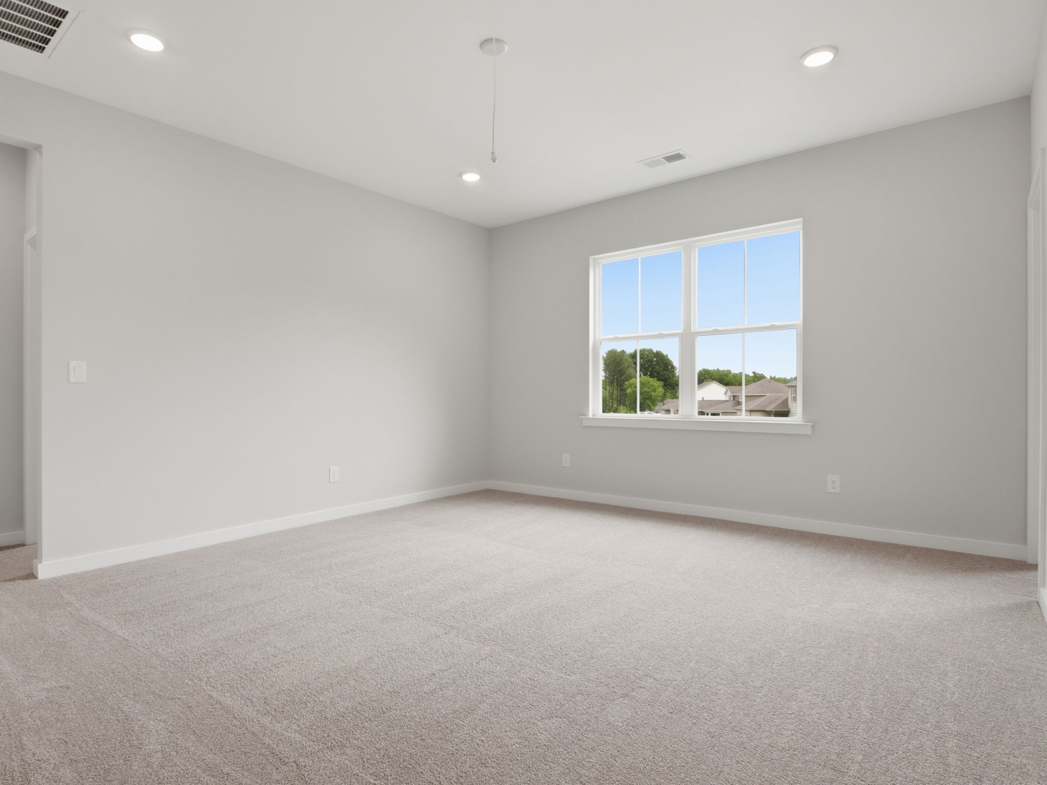 A room with a window and a carpet.