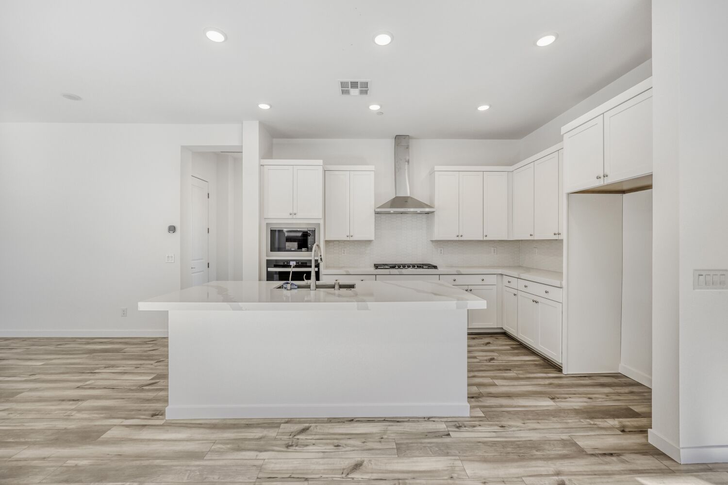 A kitchen with white cabinets.