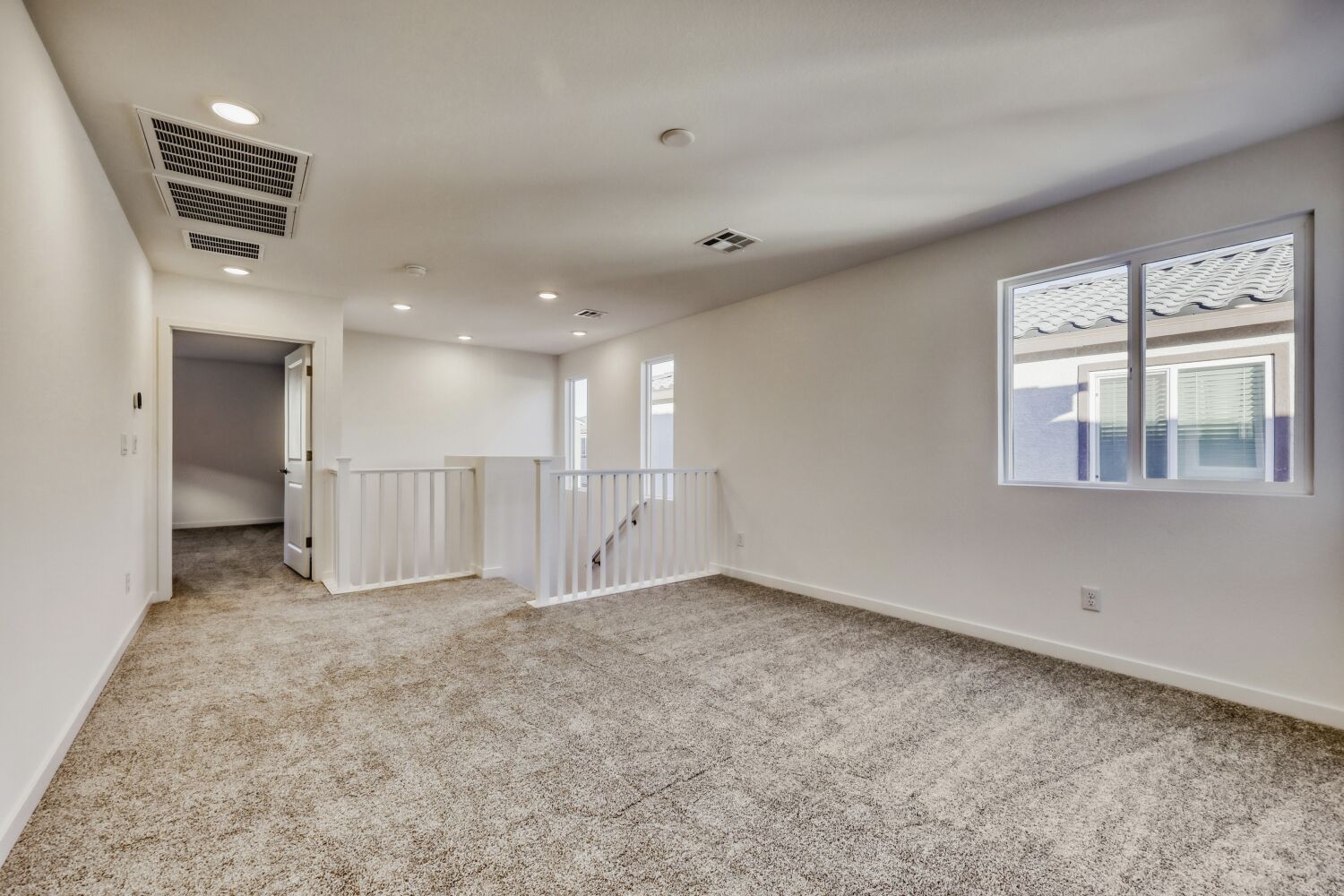 A room with a carpet and a window.