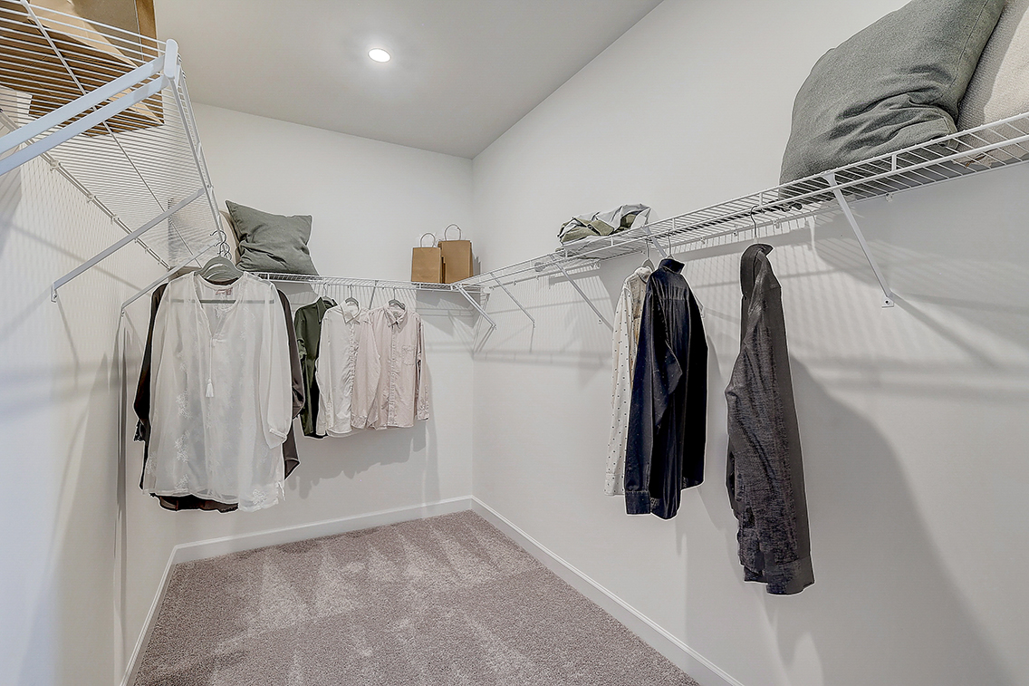 A room with a white wall and a white wall with a white cloth and a white towel rack.